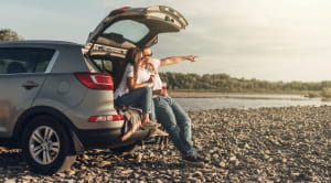 Couple sitting on open car boot